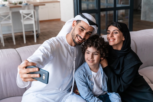Famiglia felice che trascorre del tempo insieme. Genitori arabi e momenti di stile di vita per bambini a casa