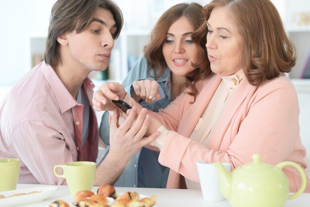 Famiglia felice che utilizza insieme il telefono cellulare