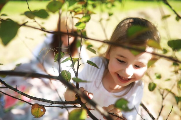 Famiglia felice con bambini che fanno picnic nel parco, genitori con bambini seduti sull'erba del giardino e che mangiano anguria all'aperto