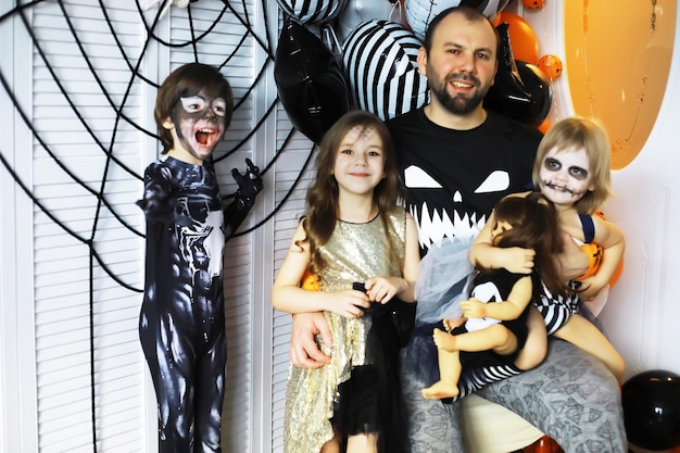 Famiglia felice con bambini in costume e trucco per la celebrazione di Halloween