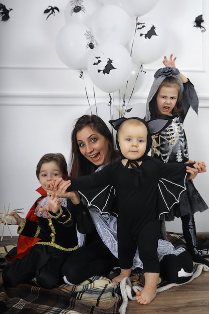 Famiglia felice con bambini in costumi di strega e vampiro in una casa in vacanza Halloween