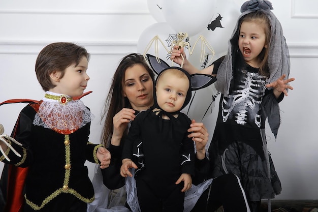 Famiglia felice con bambini in costumi di strega e vampiro in una casa in vacanza Halloween