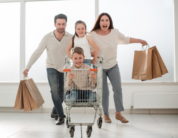 Famiglia felice con carrello e foto per bambini con spazio per la copia