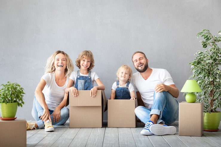 Foto famiglia felice con due bambini che giocano nella nuova casa