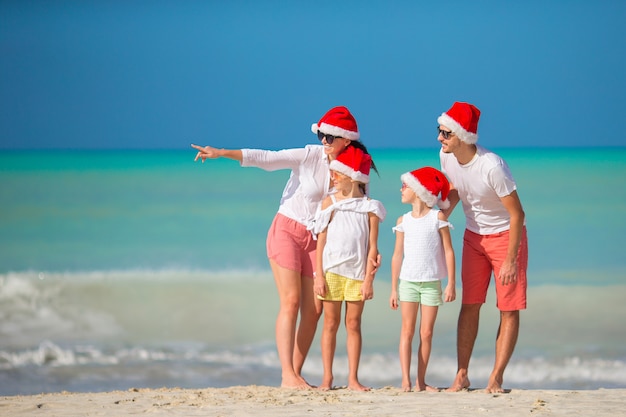 Famiglia felice con due bambini in Santa Hat in vacanza estiva