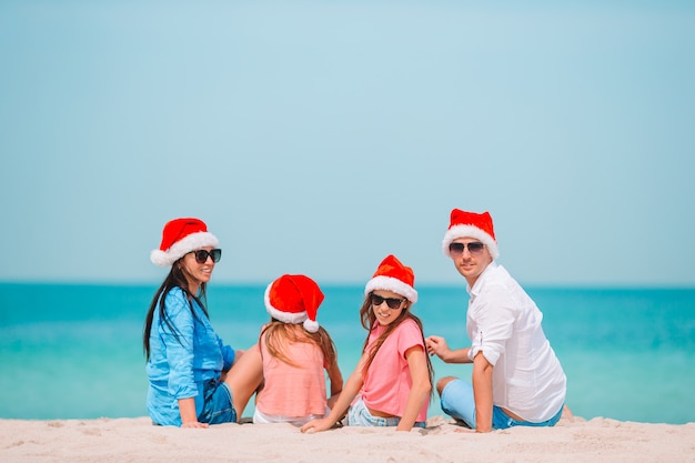 Famiglia felice con due bambini in Santa Hat in vacanza estiva