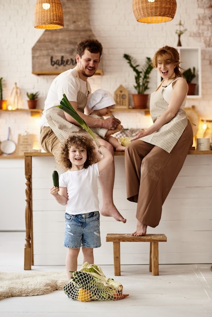 Famiglia felice con i loro figli che cucinano in cucina