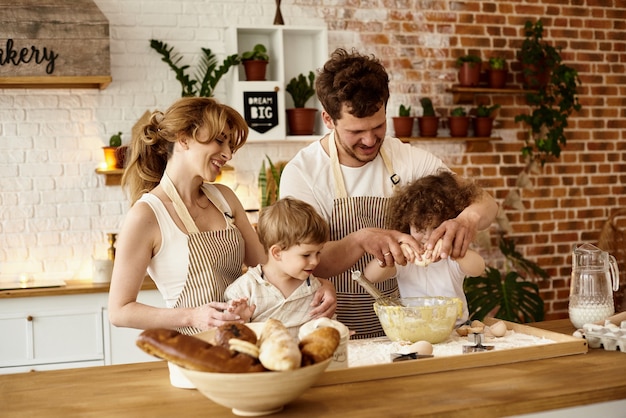 Famiglia felice con i loro figli che cucinano in cucina