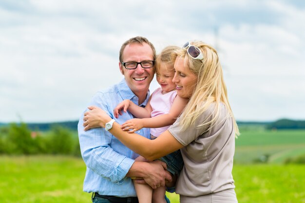 Famiglia felice con il bambino nel prato