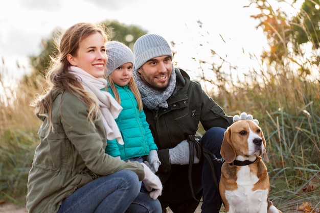 famiglia felice con il cane beagle all'aperto in autunno