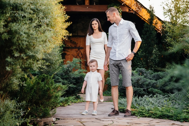 Famiglia felice con il loro figlio che cammina nel parco al tramonto. Felicità. Amore