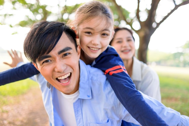 Famiglia felice con la figlia che gioca insieme nel parco