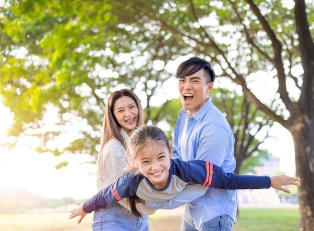 Famiglia felice con la figlia che gioca insieme nel parco