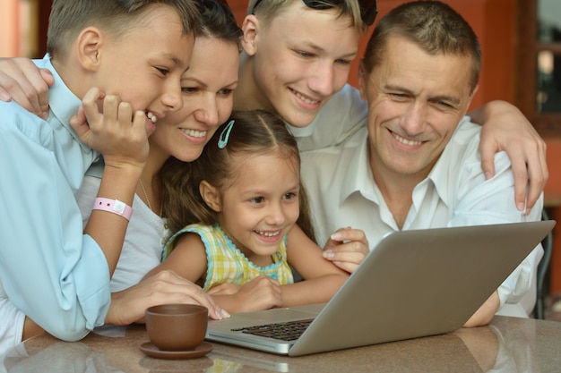 Famiglia felice con laptop a tavola