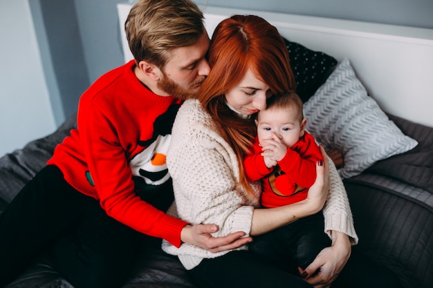 Famiglia felice con neonato sul letto