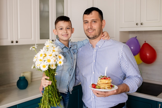 Famiglia felice con torta e fiori frittelle