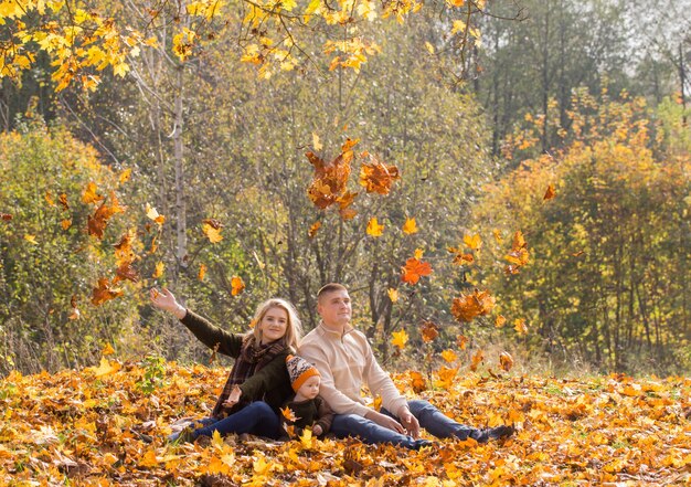 Famiglia felice con un bambino piccolo nella sosta di autunno