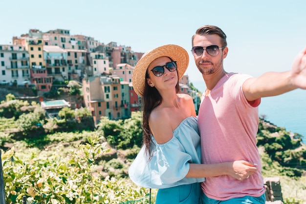 Famiglia felice con vista sul vecchio villaggio europeo nel parco nazionale delle Cinque Terre, Liguria