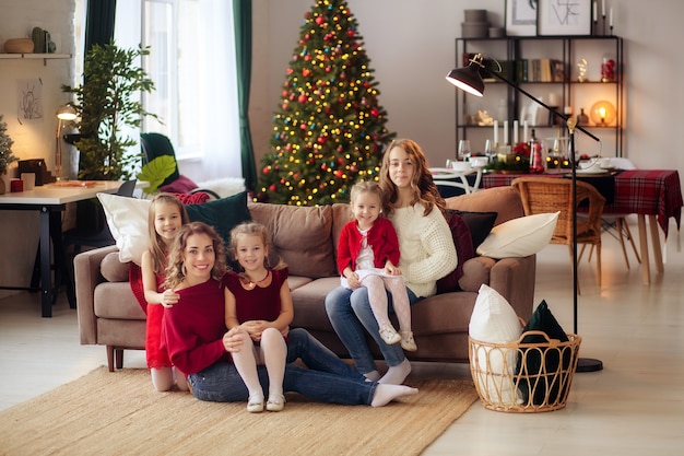 Famiglia felice dall'albero di Natale a casa con i regali