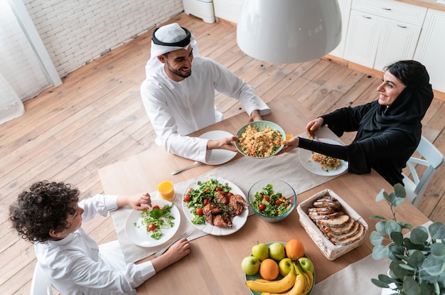 Famiglia felice degli Emirati Arabi Uniti che mangiano insieme e celebrano le festività nazionali