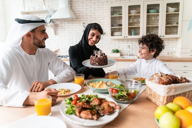 Famiglia felice degli Emirati Arabi Uniti che mangiano insieme e celebrano le festività nazionali