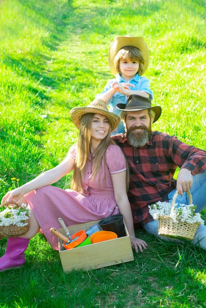 Famiglia felice del giardiniere sul picnic primaverile in giardino o nel parco. Parenthood insieme il concetto di svago.