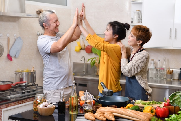 Famiglia felice della madre padre e figlia cucinare in cucina facendo cibo sano insieme sensazione di divertimento