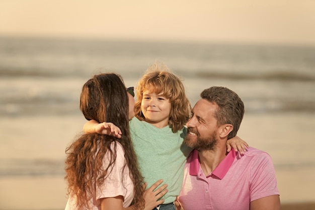 Famiglia felice di madre padre e bambino sulla spiaggia estiva