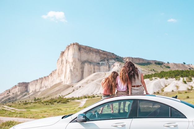 Famiglia felice di mamma e bambini in vacanza nella splendida natura durante i loro viaggi in auto