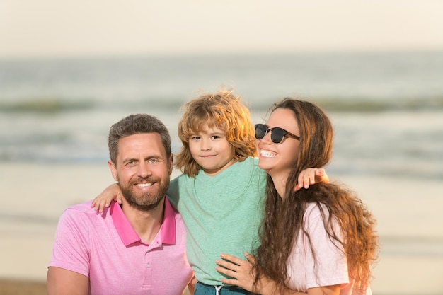 Famiglia felice di mamma papà e bambino sulla spiaggia estiva