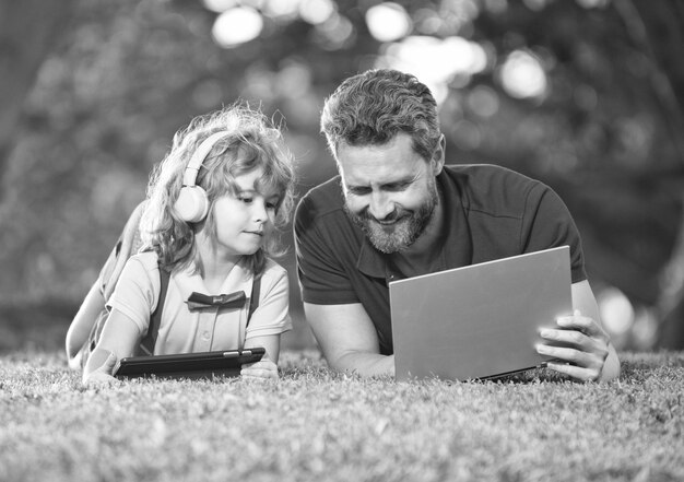 Famiglia felice di padre e figlio nella tecnologia wireless del parco