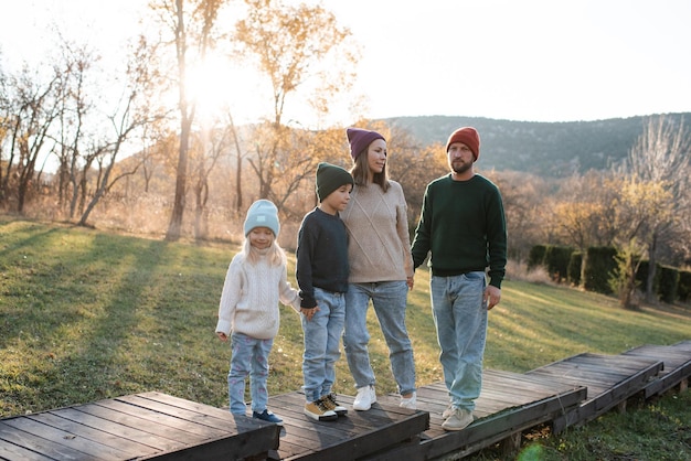 Famiglia felice di padre e madre con bambini sullo sfondo della natura autunnale in scena rustica Parenthood