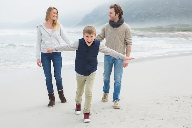 Famiglia felice di tre in spiaggia