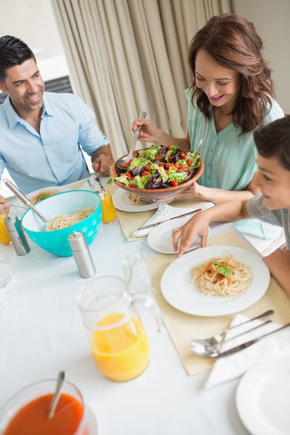 Famiglia felice di tre seduti al tavolo da pranzo