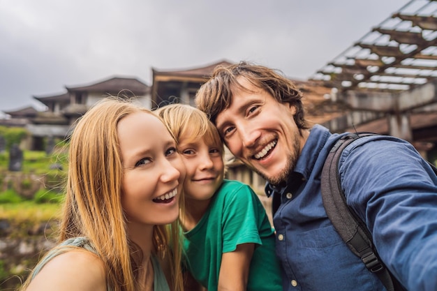 Famiglia felice di turisti in hotel abbandonato e misterioso a Bedugul Indonesia Isola di Bali