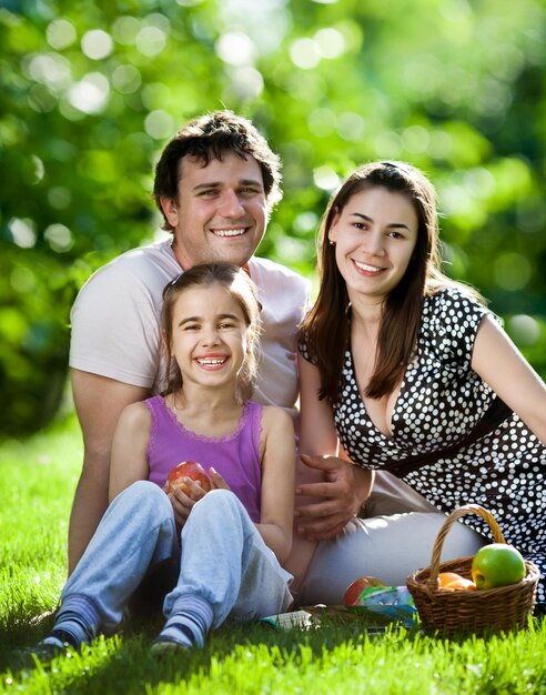 Famiglia felice divertendosi all'aperto nel parco di primavera su sfondo verde naturale