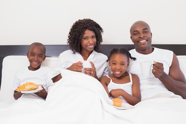 Famiglia felice facendo colazione a letto