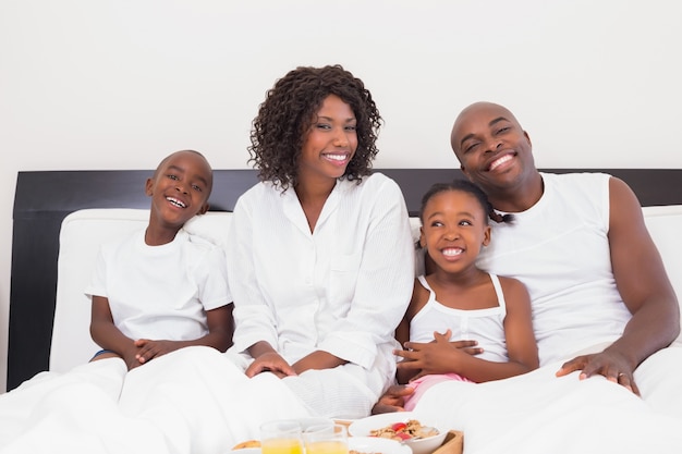 Famiglia felice facendo colazione a letto