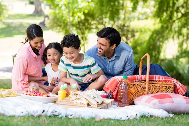 Famiglia felice facendo colazione in un parco