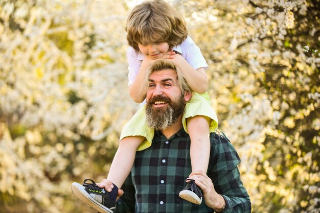 Famiglia felice Felicità della paternità Festa del papà Giornata della terra Ragazzino e padre sullo sfondo della natura Hipster e bambino figlio Concetto di felicità Passeggiata primaverile Ecologia e ambiente Felicità semplice