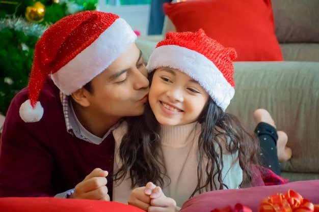 Famiglia felice. Generi la figlia di bacio in salone a casa nella festa di Natale.