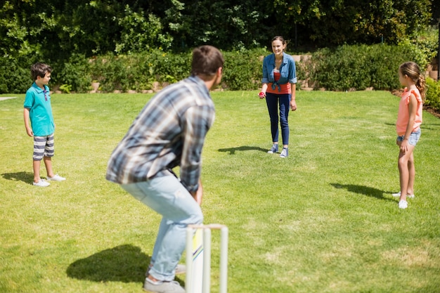 Famiglia felice giocando a cricket nel parco