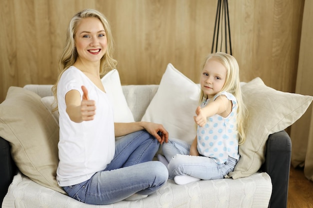 Famiglia felice. Giovane madre bionda che gioca e abbraccia con la figlia carina. Concetto di maternità.