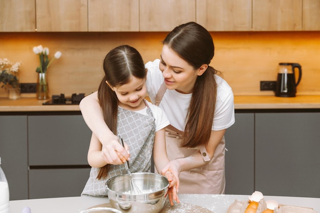 Famiglia felice in cucina madre e figlia preparano la pasta cuociono i biscotti Torta di Pasqua