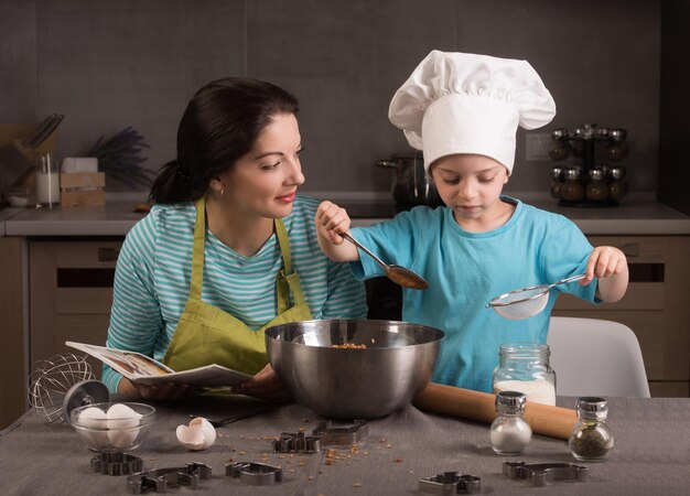 Famiglia felice in cucina Madre e figlio in cappello da chef