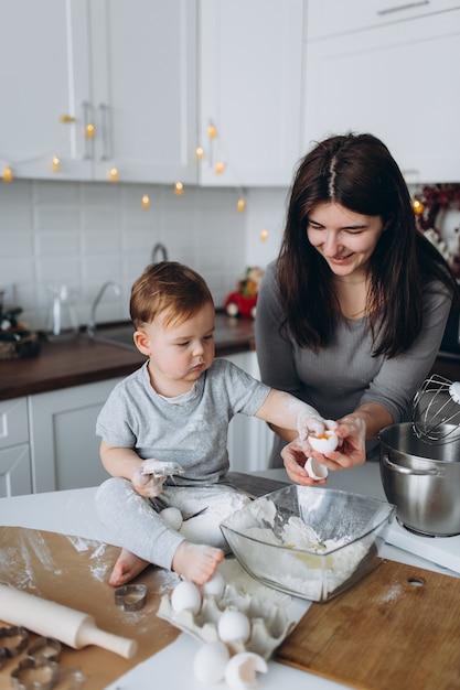 Famiglia felice in cucina. madre e figlio preparano l'impasto, cuociono i biscotti