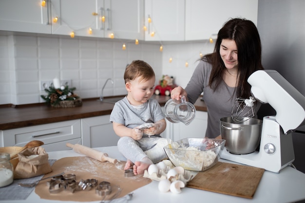 Famiglia felice in cucina. madre e figlio preparano l'impasto, cuociono i biscotti