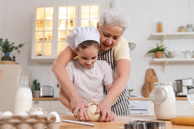 Famiglia felice in cucina nonna e nipote cucinano insieme in cucina nonna che insegna