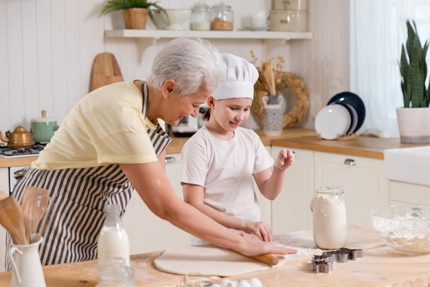 Famiglia felice in cucina nonna e nipote cucinano insieme in cucina nonna che insegna