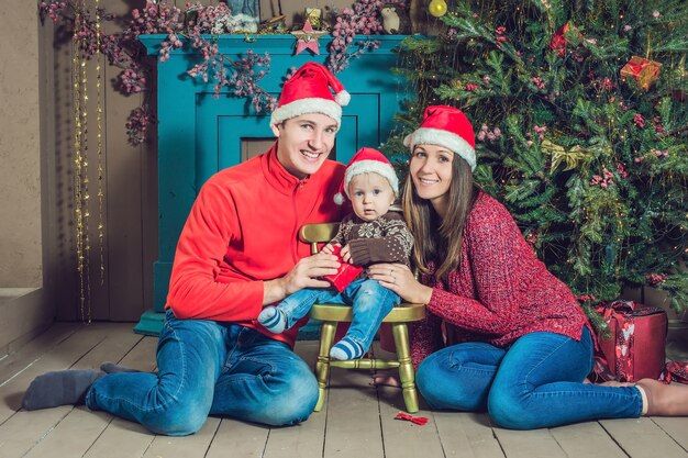 Famiglia felice in posa vicino all'albero di Natale